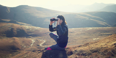 Woman in the hills using binoculars