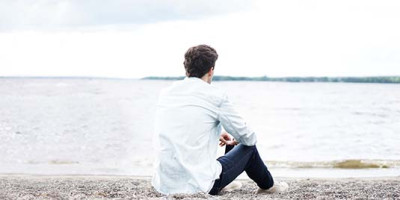 man on the beach looking at the ocean