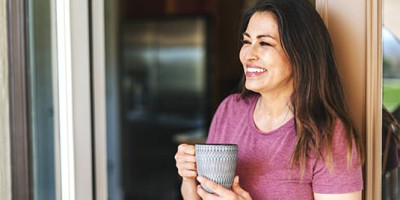woman in the doorway smiling with coffee