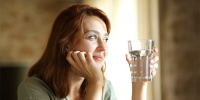 woman holding a glass of water