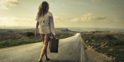 woman walking on the road with a suitcase
