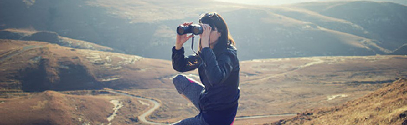 Woman in the hills using binoculars