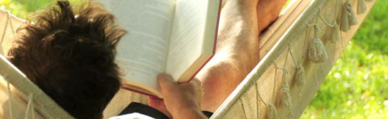 man in hammock reading a book